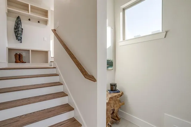 a view of a hallway with wooden floor and staircase