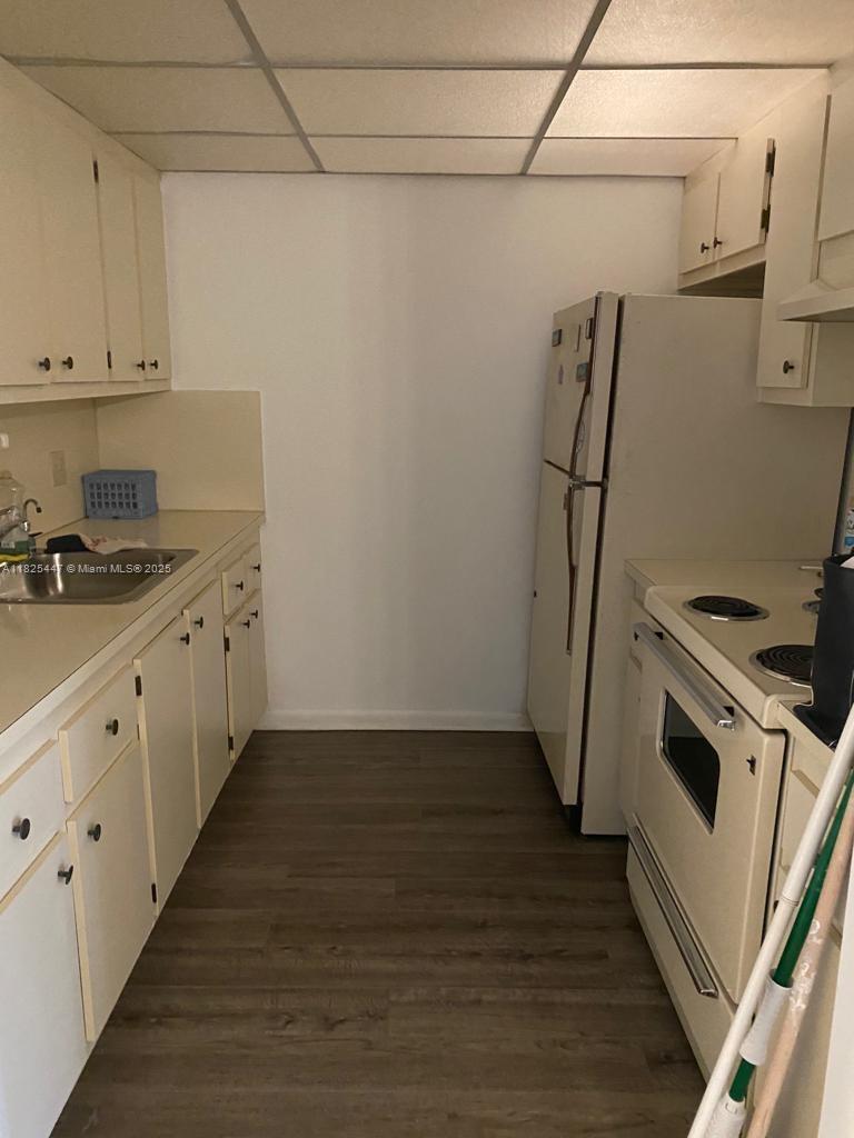 151 Southwest 134th Way, Unit 212N Pembroke Pines, FL 33027 - Photo 14 of 19 a kitchen with granite countertop white cabinets and white appliances