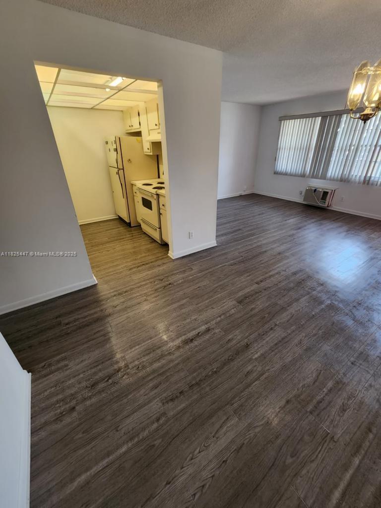 151 Southwest 134th Way, Unit 212N Pembroke Pines, FL 33027 - Photo 15 of 19 a view of an empty room with wooden floor and a window