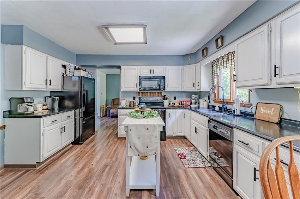 708 Margaret Road Kittanning, PA 16201 - Photo 8 of 25 a kitchen with a refrigerator a stove top oven a sink dishwasher and white cabinets with wooden floor