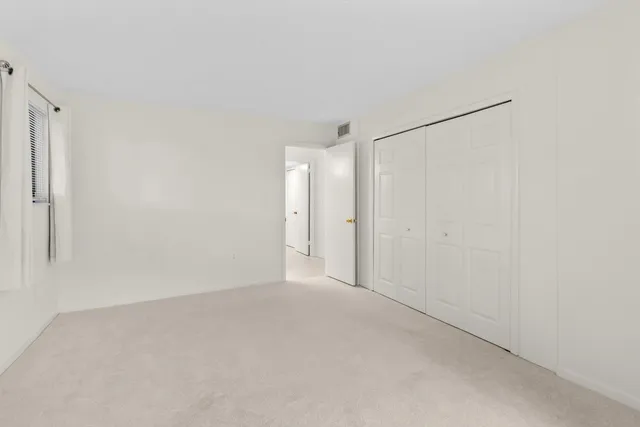 a spacious bedroom with a bed and a lamp