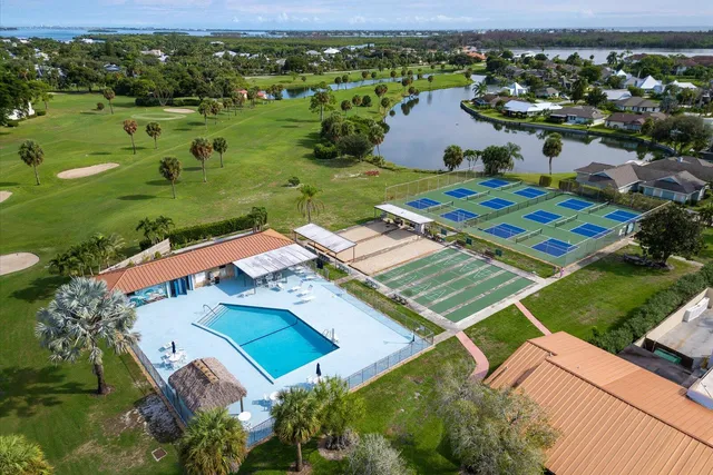 an aerial view of residential houses with outdoor space and trees