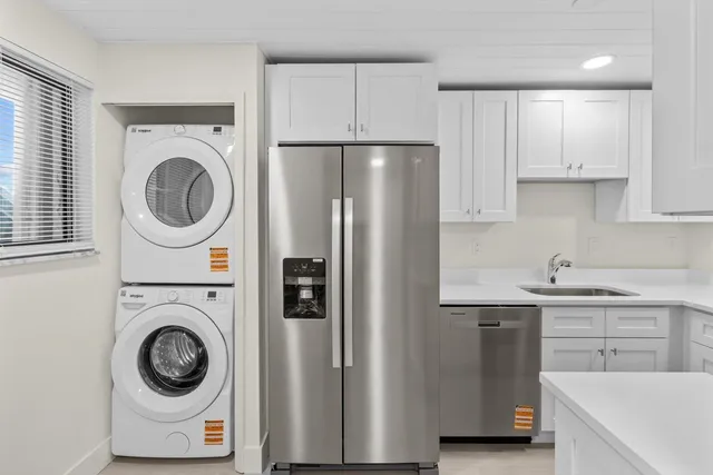 a kitchen with a refrigerator sink and cabinets