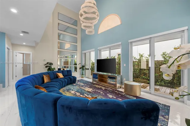 a living room with furniture a flat screen tv and a large window