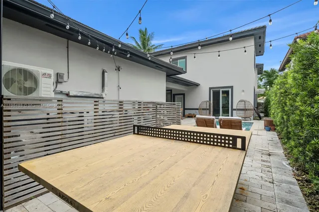 a view of a house with a yard and palm trees