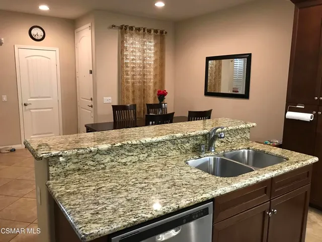 a bathroom with a granite countertop sink a mirror and shower
