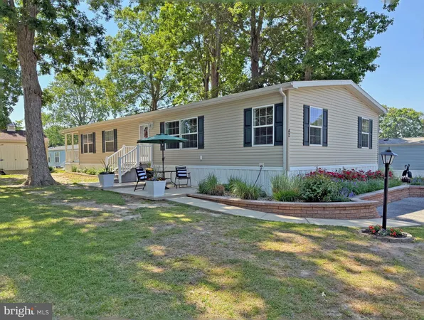 a front view of house with yard and trees in the background