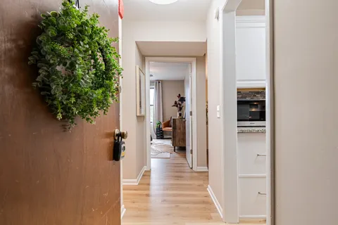 a view of a hallway with wooden floor and a potted plant