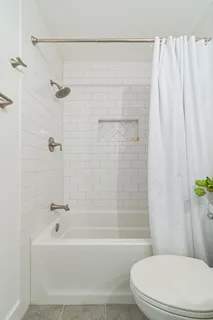 a white toilet sitting next to a bath tub