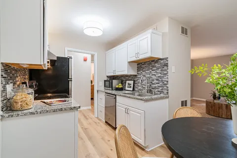 a kitchen with stainless steel appliances kitchen island granite countertop a stove refrigerator and microwave