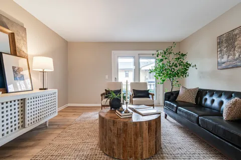 a living room with furniture and a potted plant