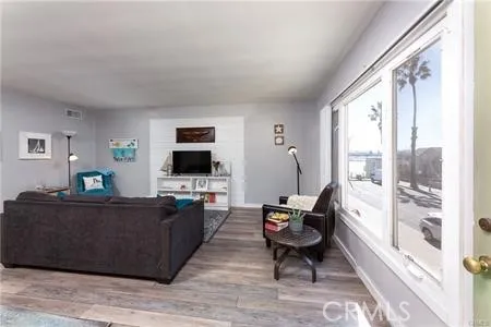 a living room with furniture a flat screen tv and a large window