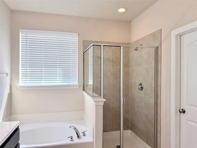 a bathroom with a shower and a bath tub