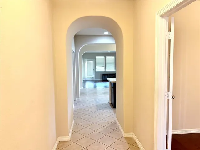 a view of a hallway with a glass space and a bathroom