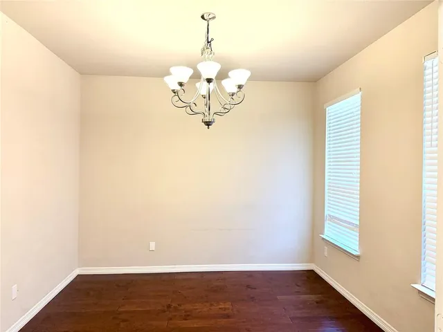 a view of a room with wooden floor and a window