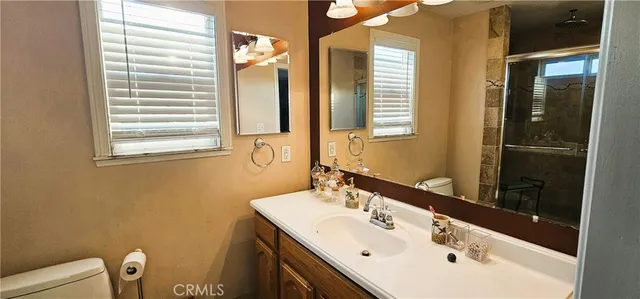 a bathroom with a sink mirror and a toilet
