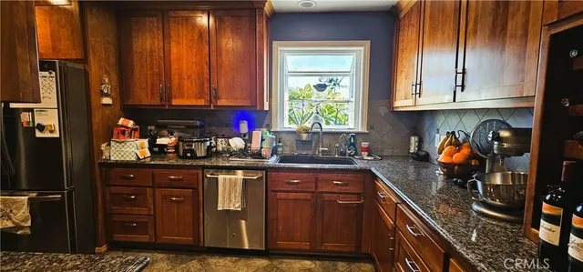 a kitchen with stainless steel appliances granite countertop a refrigerator and sink