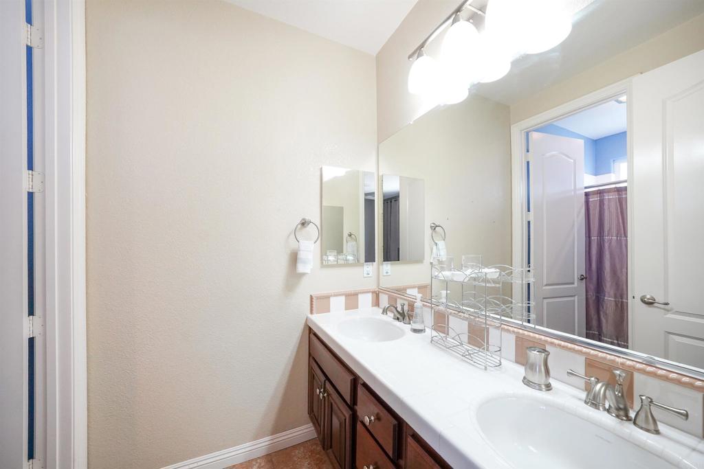 22963 Stokes Road Ramona, CA 92065 - Photo 42 of 57 a bathroom with a double vanity sink and a mirror