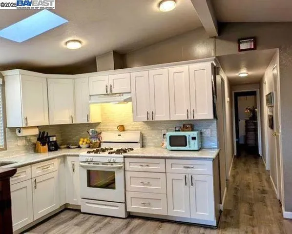 a kitchen with white cabinets and white appliances