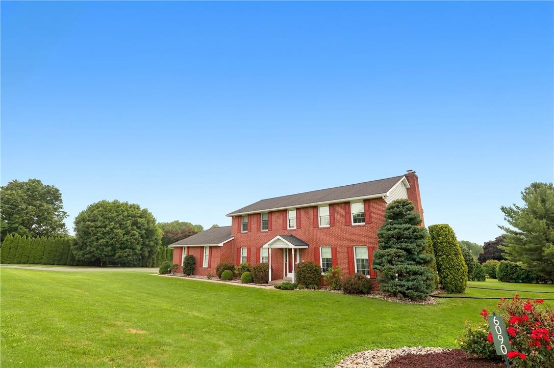 6090 Stone Post Road Bath, PA 18014 - Photo 4 of 57 A classic brick-front residence presents a welcoming facade with a covered entry and manicured grounds.