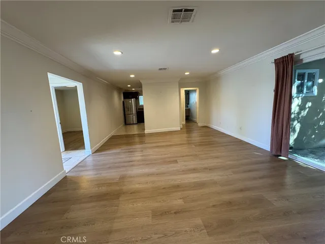 an empty room with wooden floor and entrance