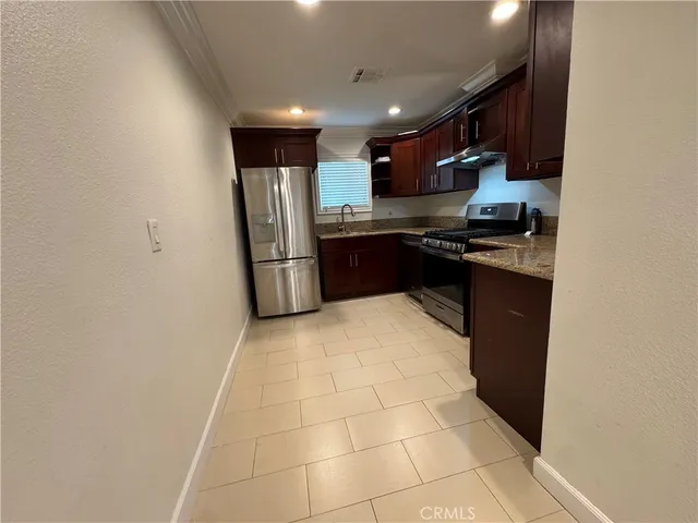 a kitchen with stainless steel appliances granite countertop a refrigerator and a stove
