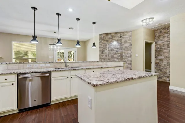 a kitchen with a sink a stove cabinets and wooden floor