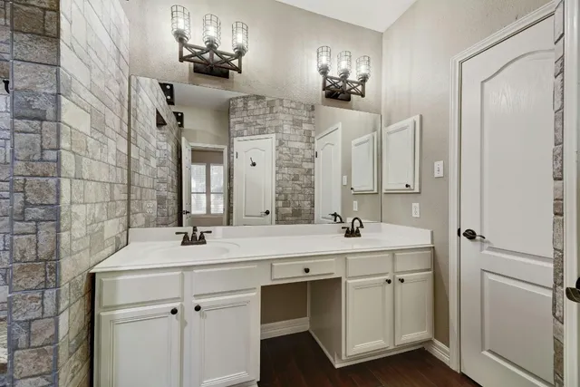 a bathroom with a sink a vanity and shower