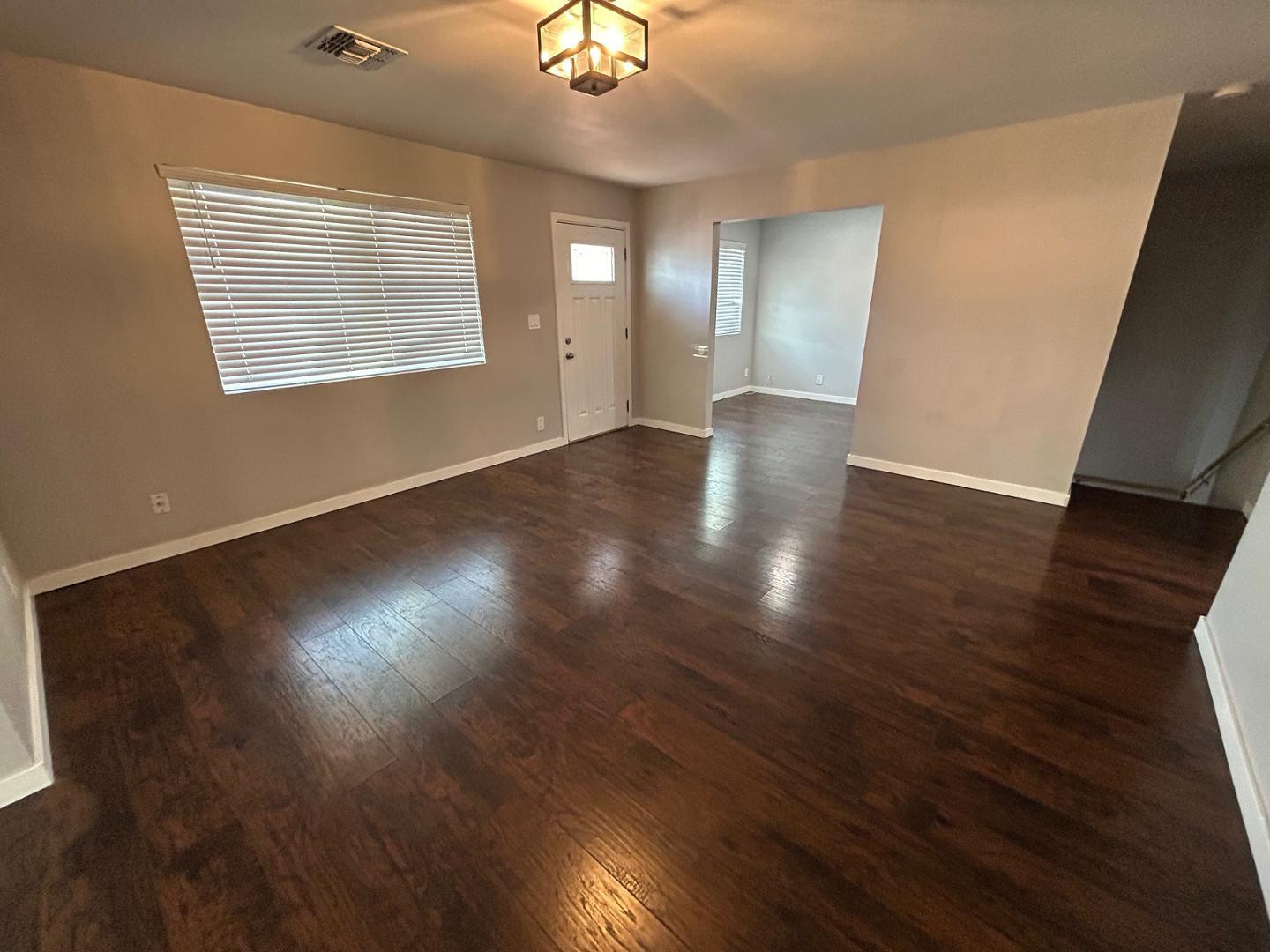 1117 West 9th Street Tempe, AZ 85281 - Photo 2 of 22 an empty room with wooden floor and windows