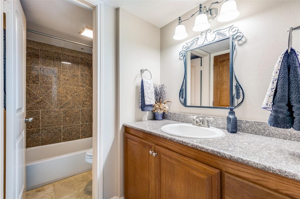 447 Josephine Street Dallas, TX 75246 - Photo 17 of 26 a bathroom with a granite countertop sink mirror and a bathtub