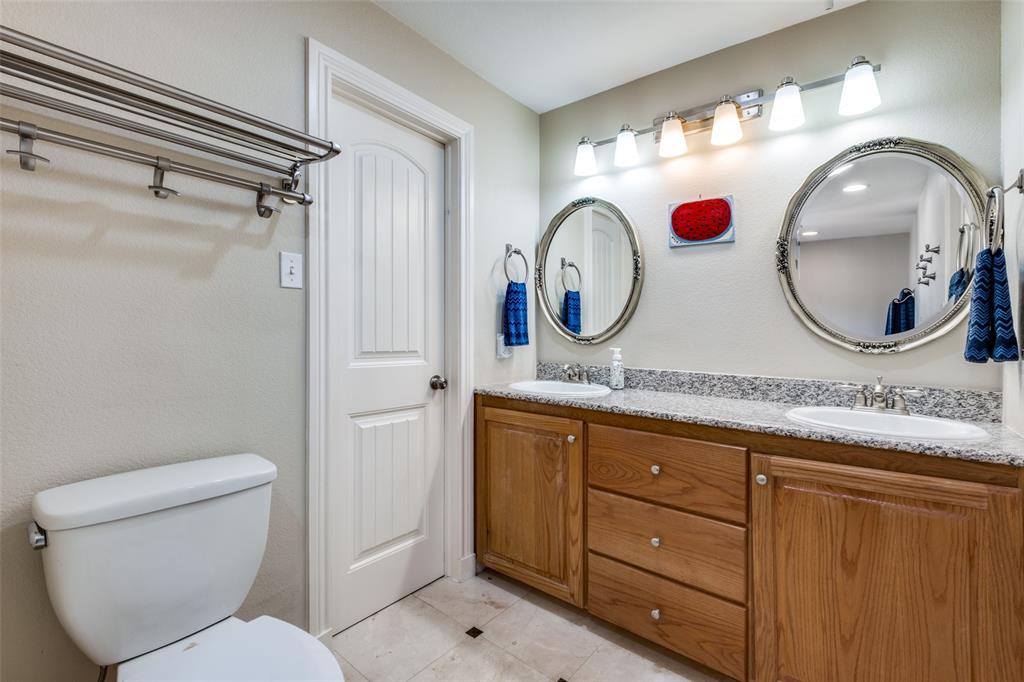 447 Josephine Street Dallas, TX 75246 - Photo 19 of 26 a bathroom with a toilet a sink and a mirror