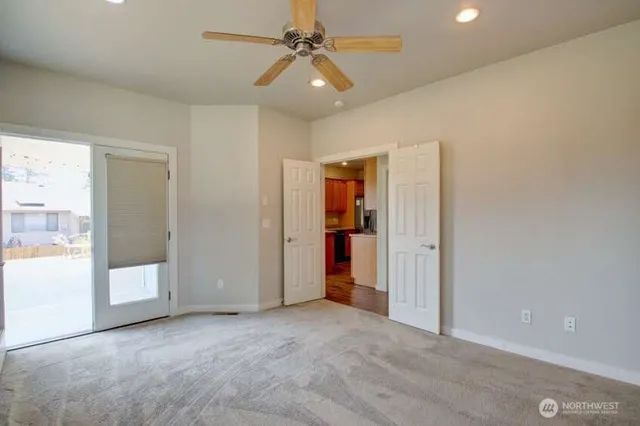 an empty room with fan and windows