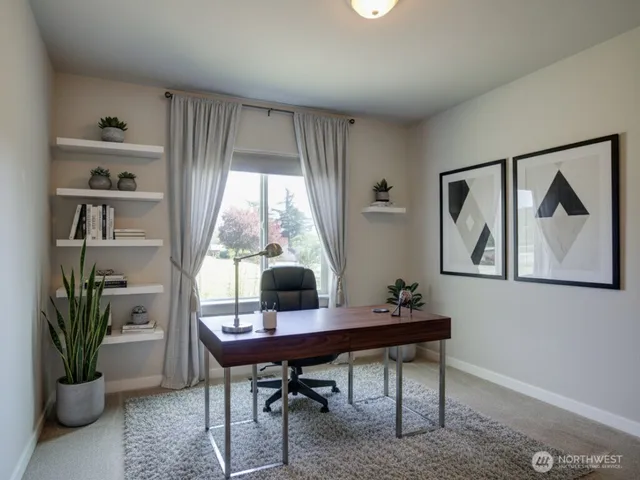 a view of a workspace with furniture and a window