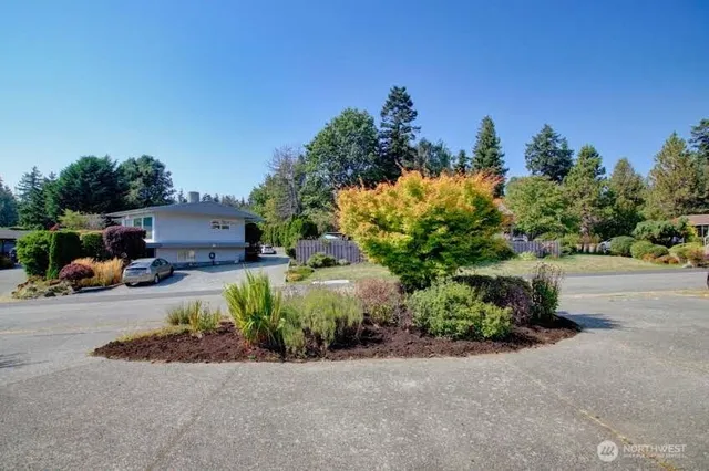 a front view of a house with a yard and trees