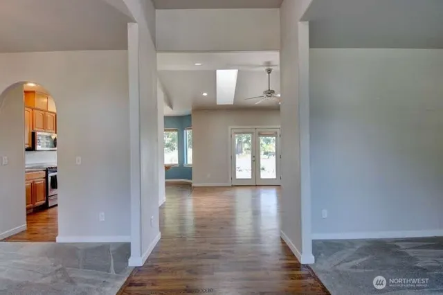 a view of a hallway with wooden floor and a living room