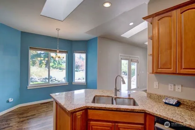 a kitchen with granite countertop a sink cabinets and window