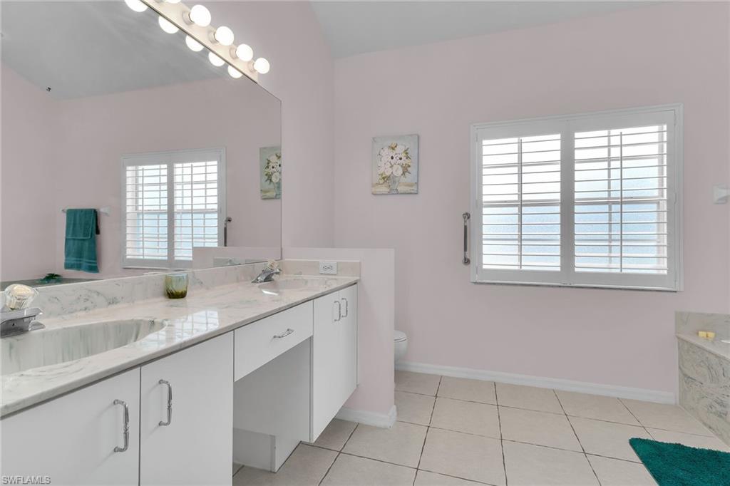 2880 Orange Grove Trail Naples, FL 34120 - Photo 14 of 42 a bathroom with a granite countertop sink a large mirror and a window