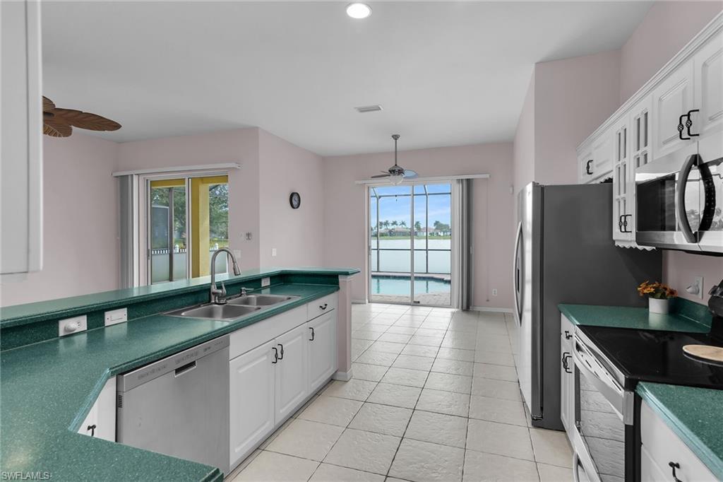 2880 Orange Grove Trail Naples, FL 34120 - Photo 10 of 42 a kitchen with stainless steel appliances granite countertop a sink and a refrigerator