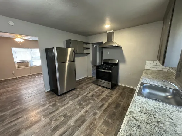 a kitchen with a refrigerator and a stove