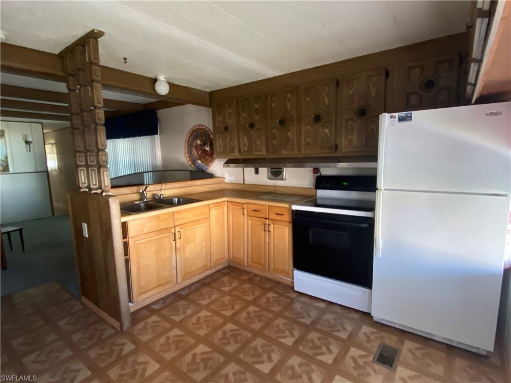 26 Cheyenne Trail, Unit 168 Naples, FL 34113 - Photo 12 of 21 a kitchen with a refrigerator sink and cabinets