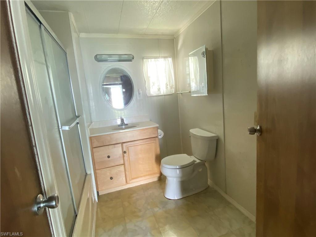 26 Cheyenne Trail, Unit 168 Naples, FL 34113 - Photo 21 of 21 a bathroom with a toilet a sink a vanity and mirror