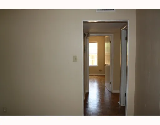 a view of a hallway with wooden floor and a living room
