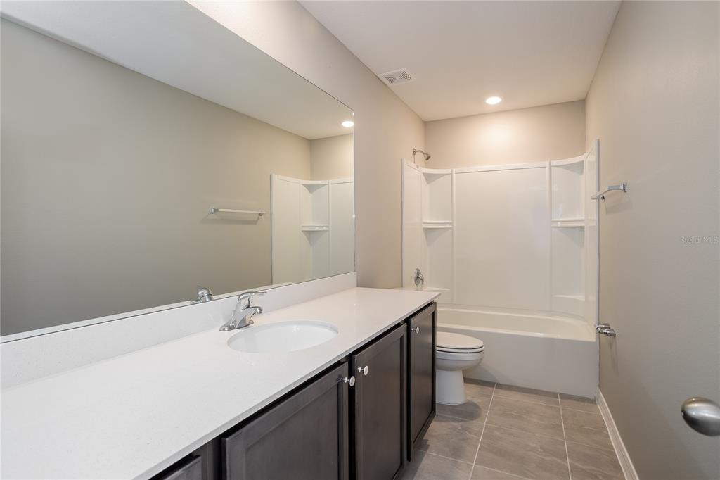 349 Daffodil Lane Kissimmee, FL 34759 - Photo 12 of 16 a bathroom with a sink a toilet and shower