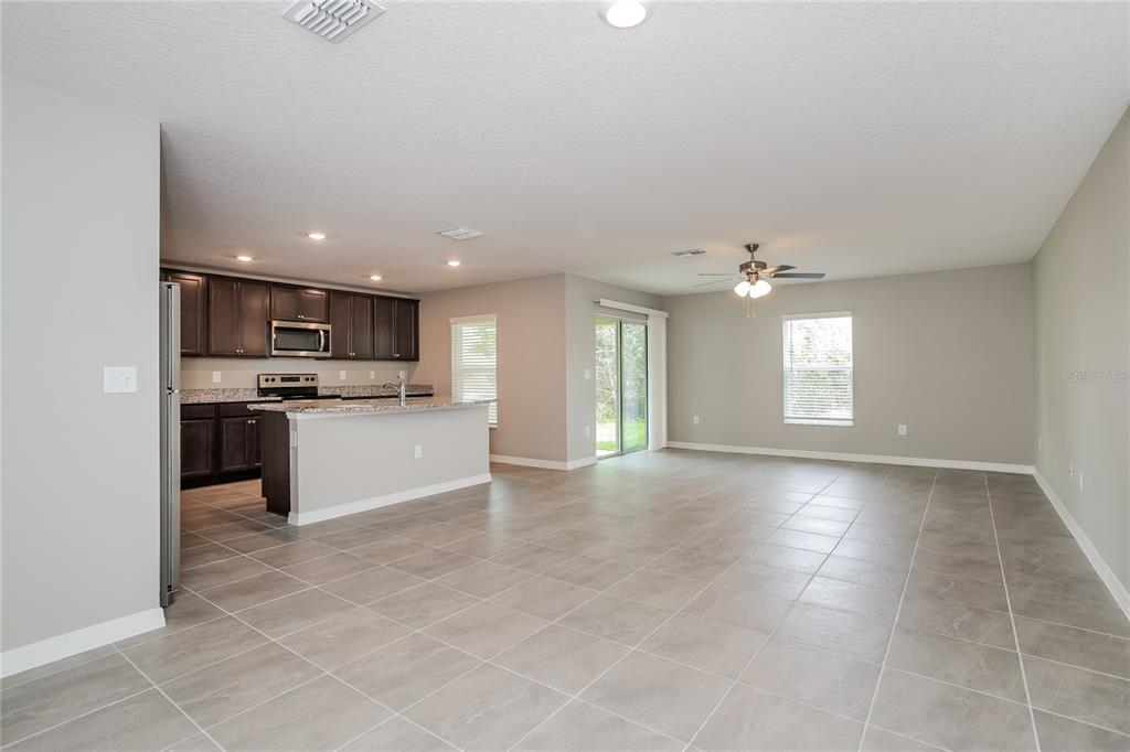 349 Daffodil Lane Kissimmee, FL 34759 - Photo 2 of 16 a view of a kitchen with kitchen island wooden cabinets and center island
