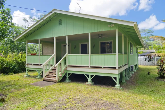 a backyard of a house with wooden deck and furniture