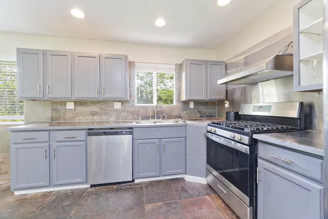 a kitchen with granite countertop white cabinets and white appliances