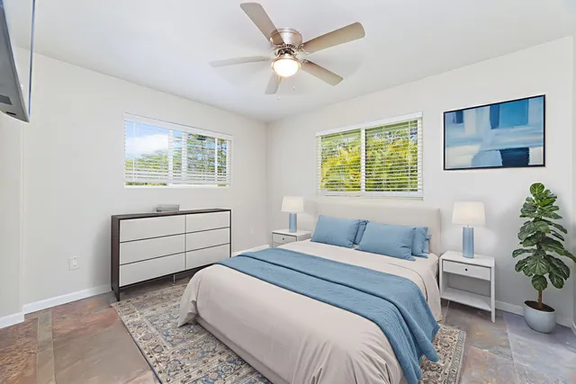 an empty room with windows and ceiling fan