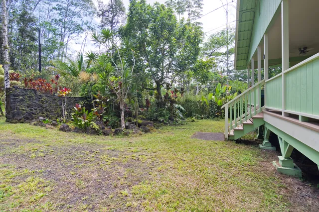 a backyard of a house with lots of green space and a fountain
