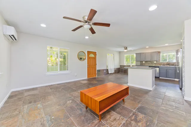 a living room with a couch and kitchen view