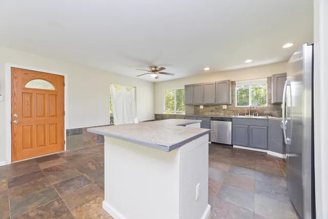 a kitchen with a sink refrigerator and cabinets
